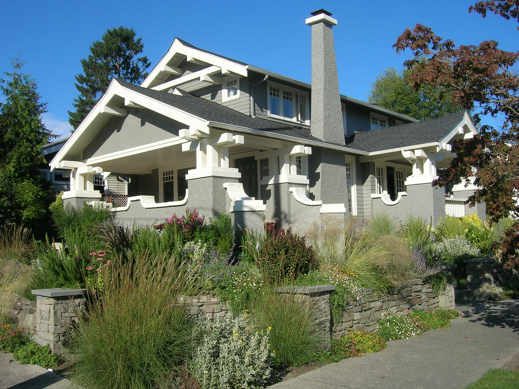 Two-story Craftsman house with a covered front porch and garden